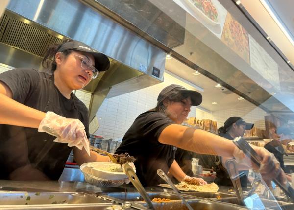 Chipotle workers fill orders at restaurant on April 1, 2024.